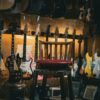 A cozy music store with a variety of guitars on display and a single chair in the center.