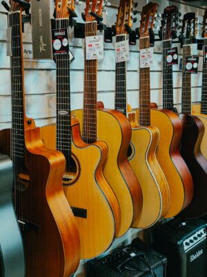 A row of beautifully crafted acoustic guitars on display in a music store, highlighting variety and craftsmanship.