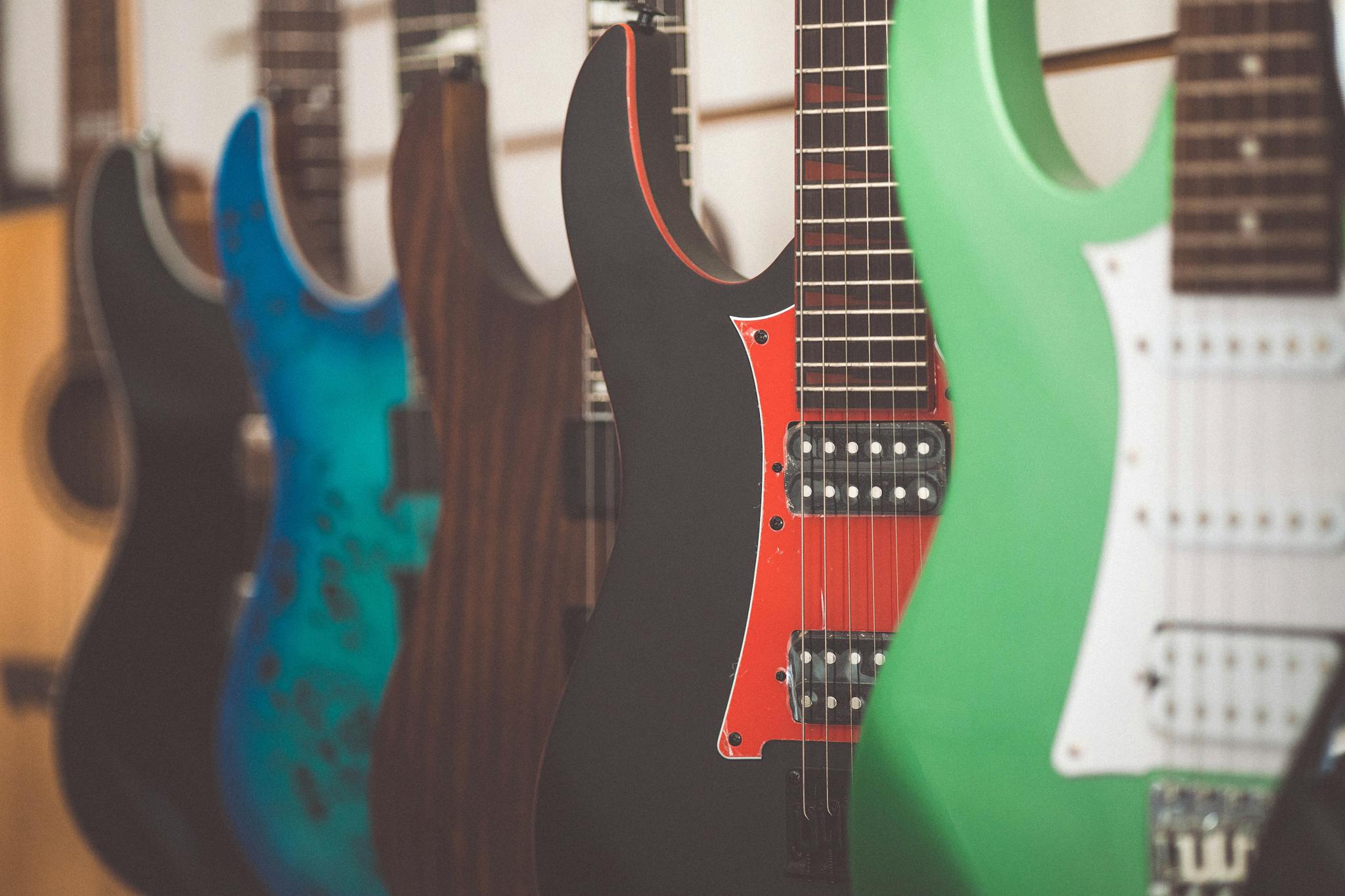 Colorful electric guitars lined up in a music store display, highlighting different styles and finishes.