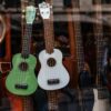 Shop window showcasing a collection of colorful ukuleles and guitars.
