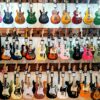 Vibrant collection of electric guitars on display in a music store, showcasing diverse models and colors.