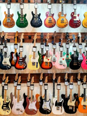 Vibrant collection of electric guitars on display in a music store, showcasing diverse models and colors.